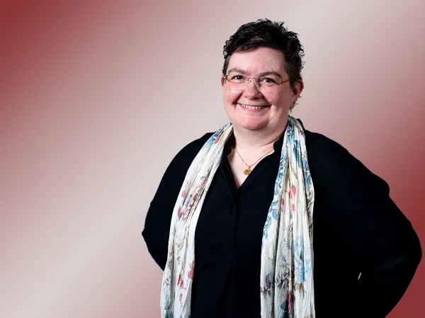 Porträt einer Frau mit kurzen braunen Haaren und Schal.