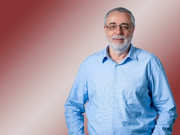 Porträt eines Mannes mit hellblauem Hemd und Brille,