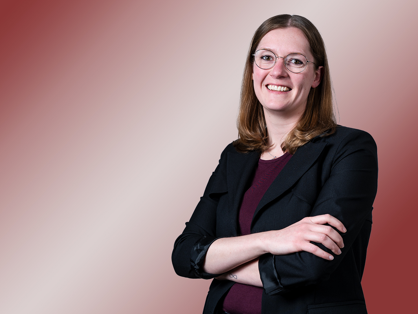 Porträt einer Frau mit schwarzem Blazer und Brille.