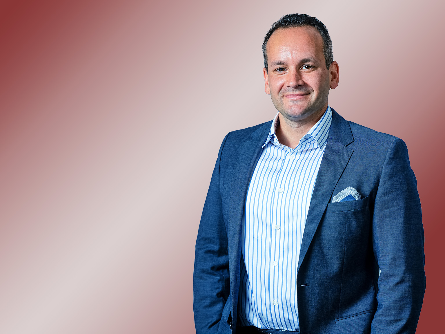 Porträt eines brünetten Mannes mit blauem Blazer.