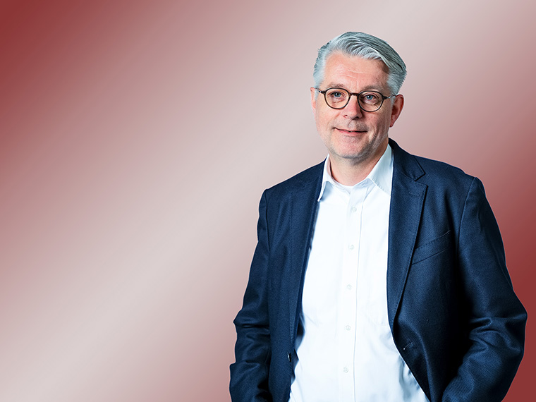 Porträt eines Mannes mit Blazer und Hemd.