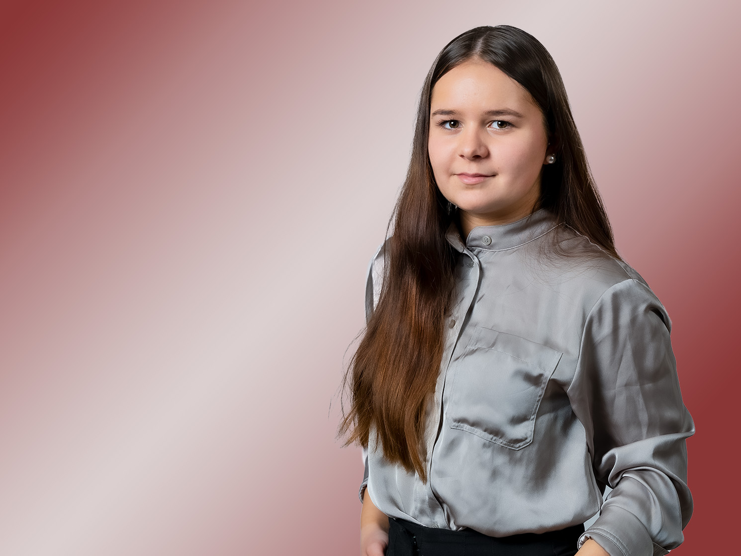 Porträt einer Frau mit langen braunen Haaren und grünem Hemd.