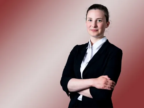 Porträt einer jungen brünetten Frau mit schwarzem Blazer.